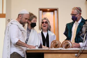 Joan chanting Torah with Rabbi Eli, Kim Herb, and Rabbi Gary