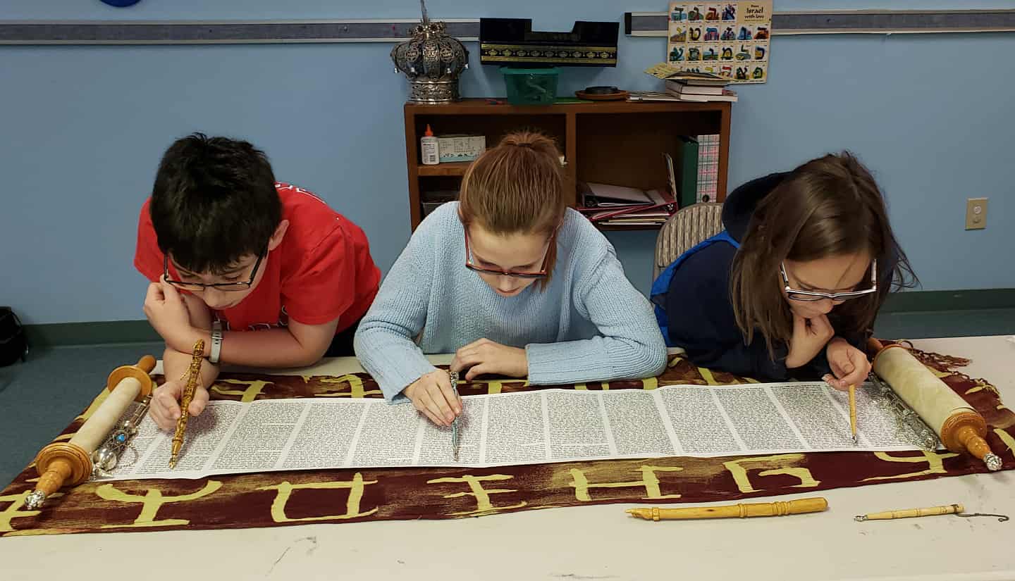 B'nai Mitzvah students practicing reading from Torah scroll